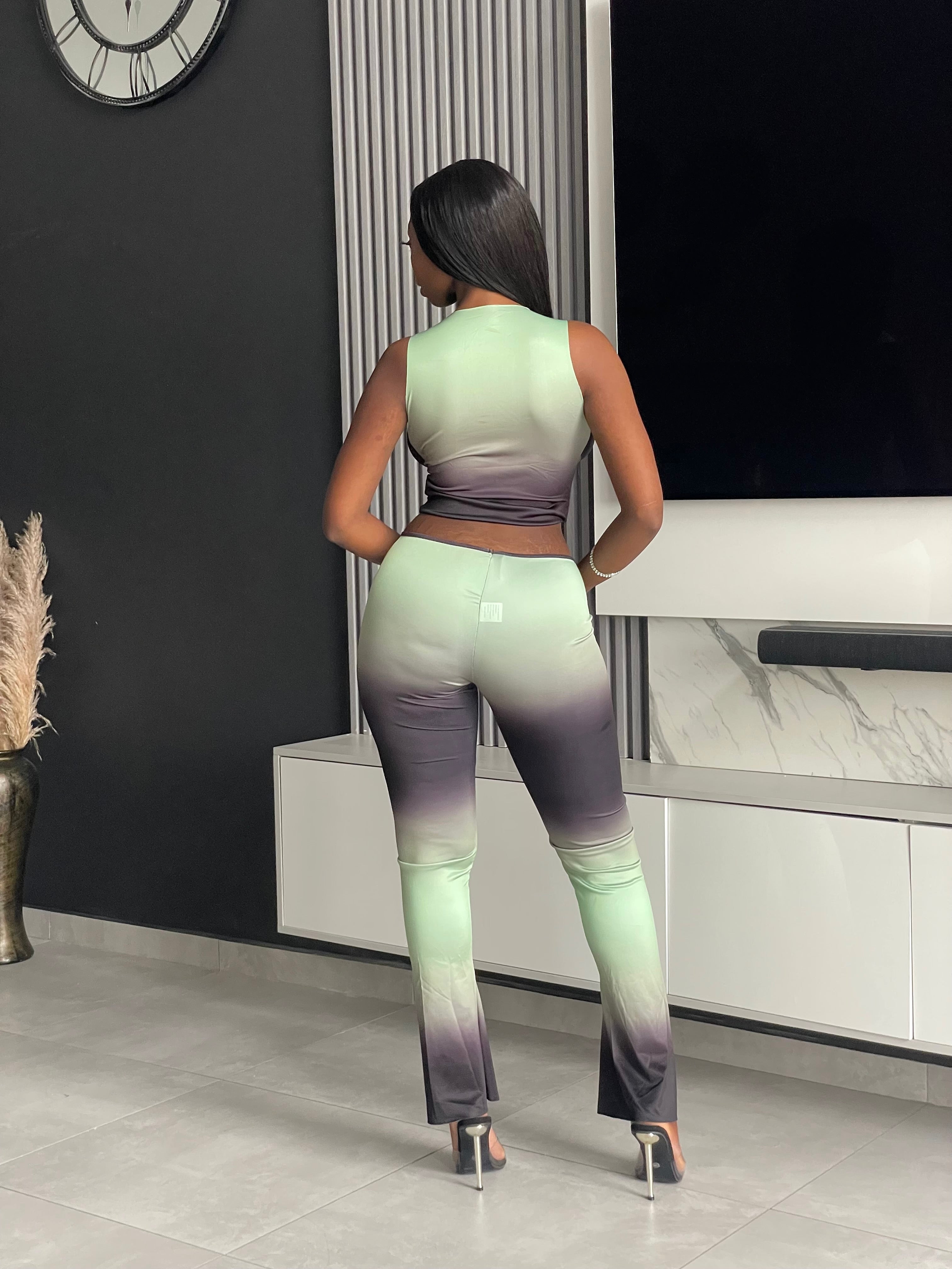 Model wearing the Pasty Pant Set, a chic ombre two-piece outfit with a fitted crop top and flared pants in green and black.