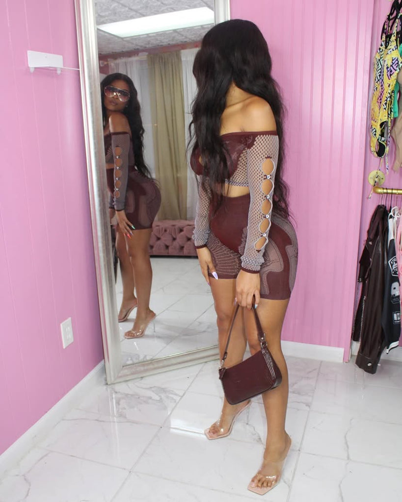 Woman wearing the Aubrey Mesh Two-Piece Set featuring an off-shoulder crop top with mesh sleeves and high-waisted shorts in chocolate brown.