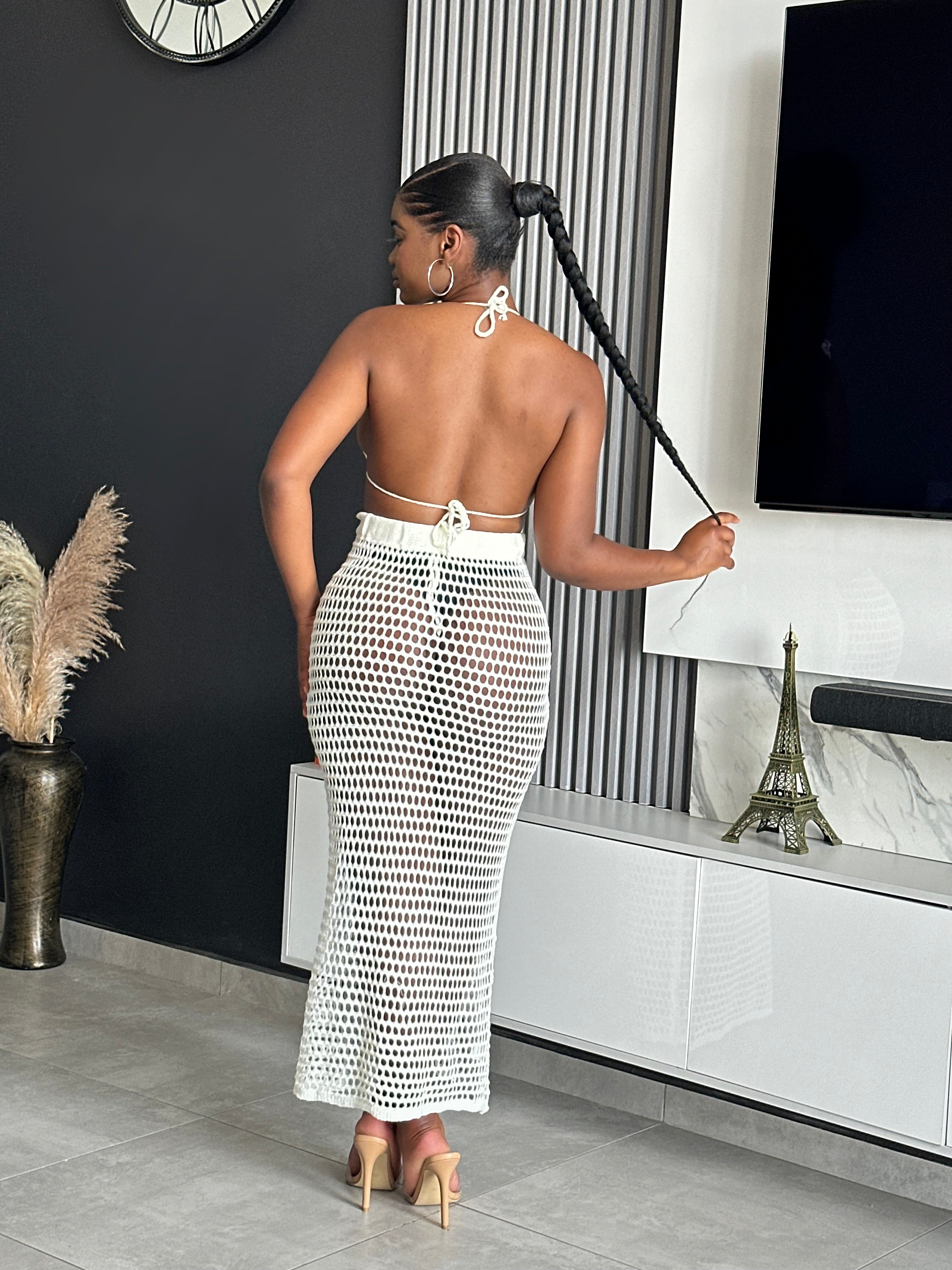 Model wearing the Jordyn Maxi Skirt Set in white, featuring a halter crochet top and matching see-through maxi skirt