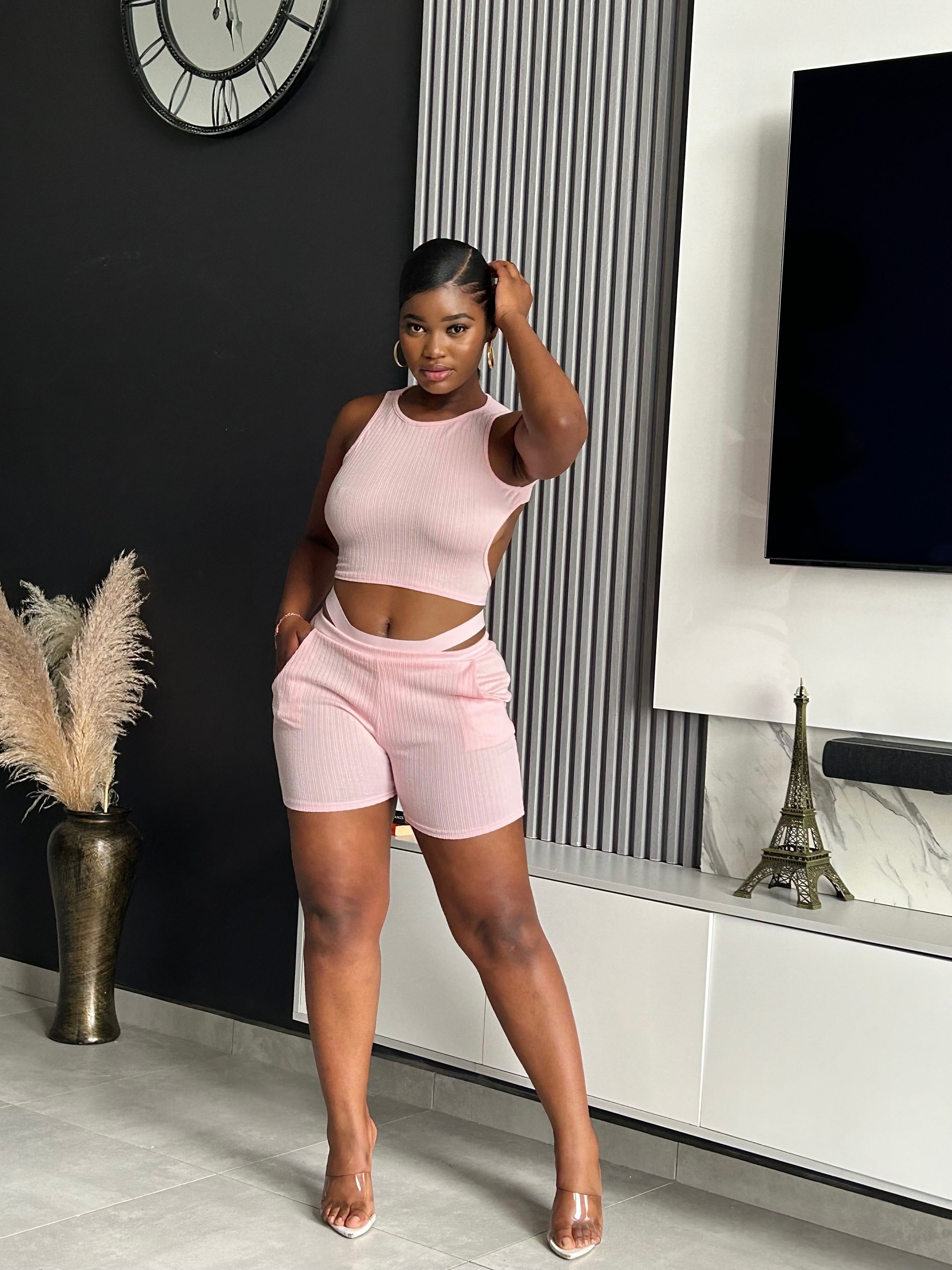 Model wearing the Liane Ribbed Short Set in pink, featuring a ribbed texture and cutout waistband, offering a normal fit with good stretch.