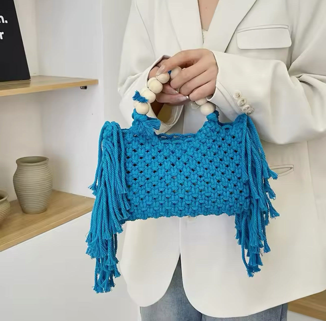 Handwoven macramé handbag with wooden bead handles and fringe details, perfect for casual outings and boho style.