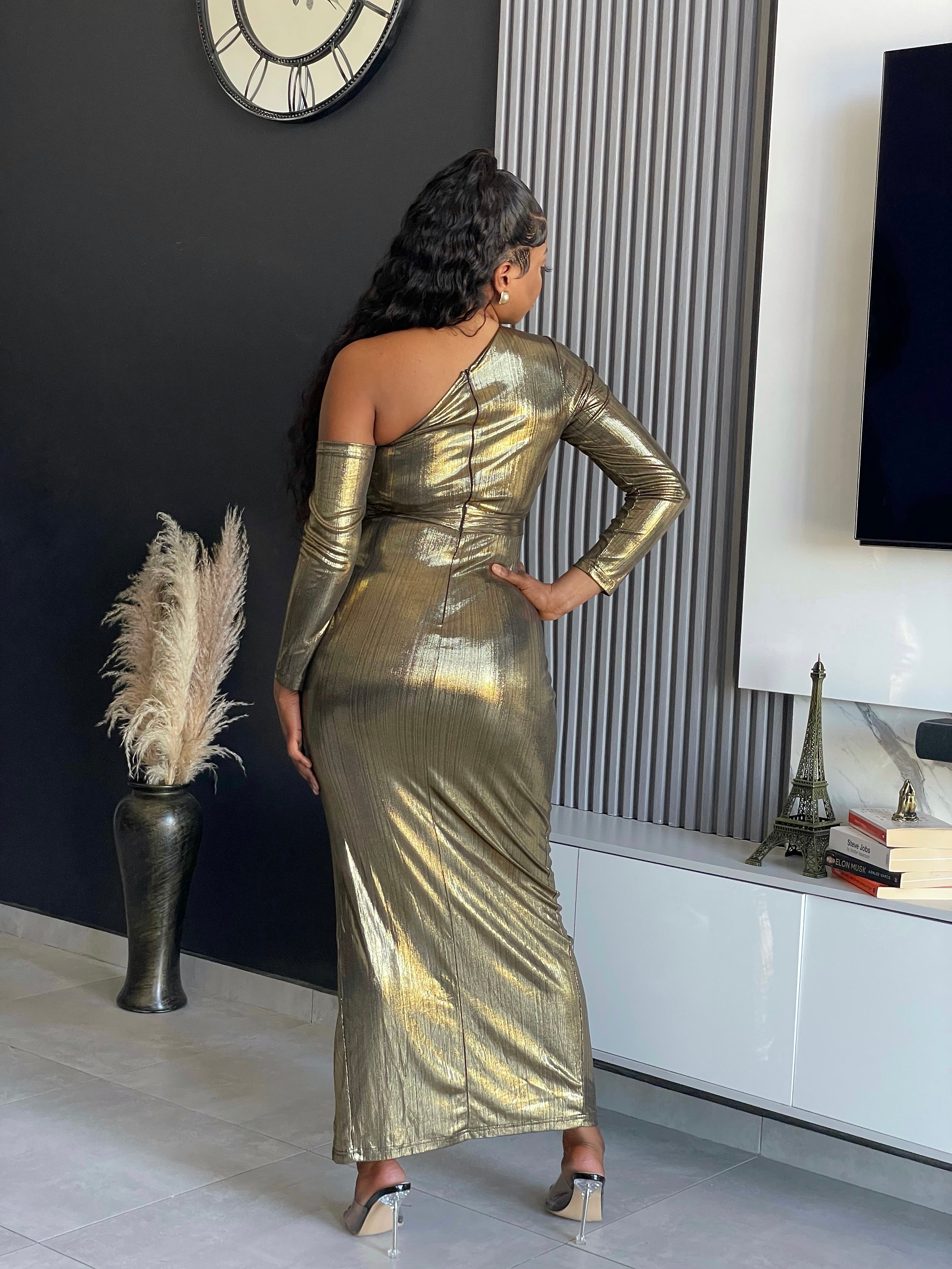 Model wearing the Aiko Metallic Gown, a glamorous one-shoulder metallic gown with a high slit and ruched details from Vera’s Closet.