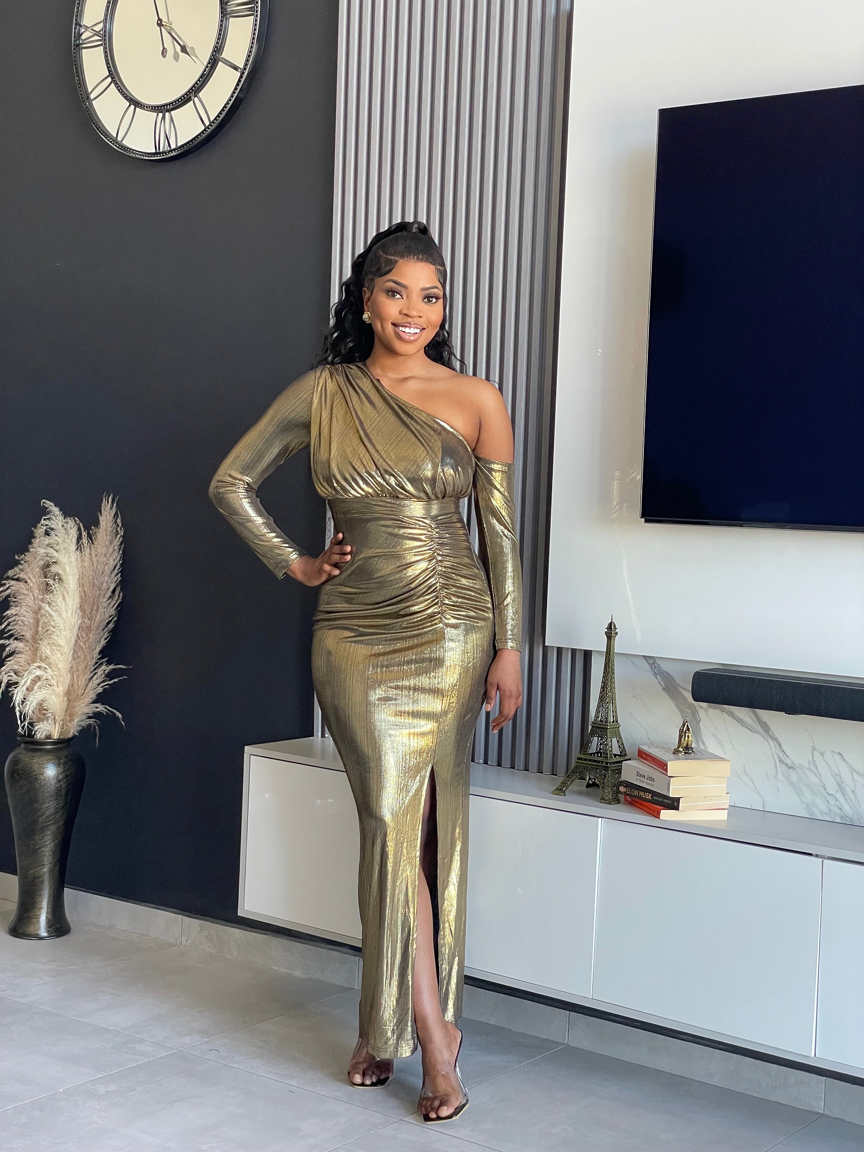 Model wearing the Aiko Metallic Gown, a glamorous one-shoulder metallic gown with a high slit and ruched details from Vera’s Closet.