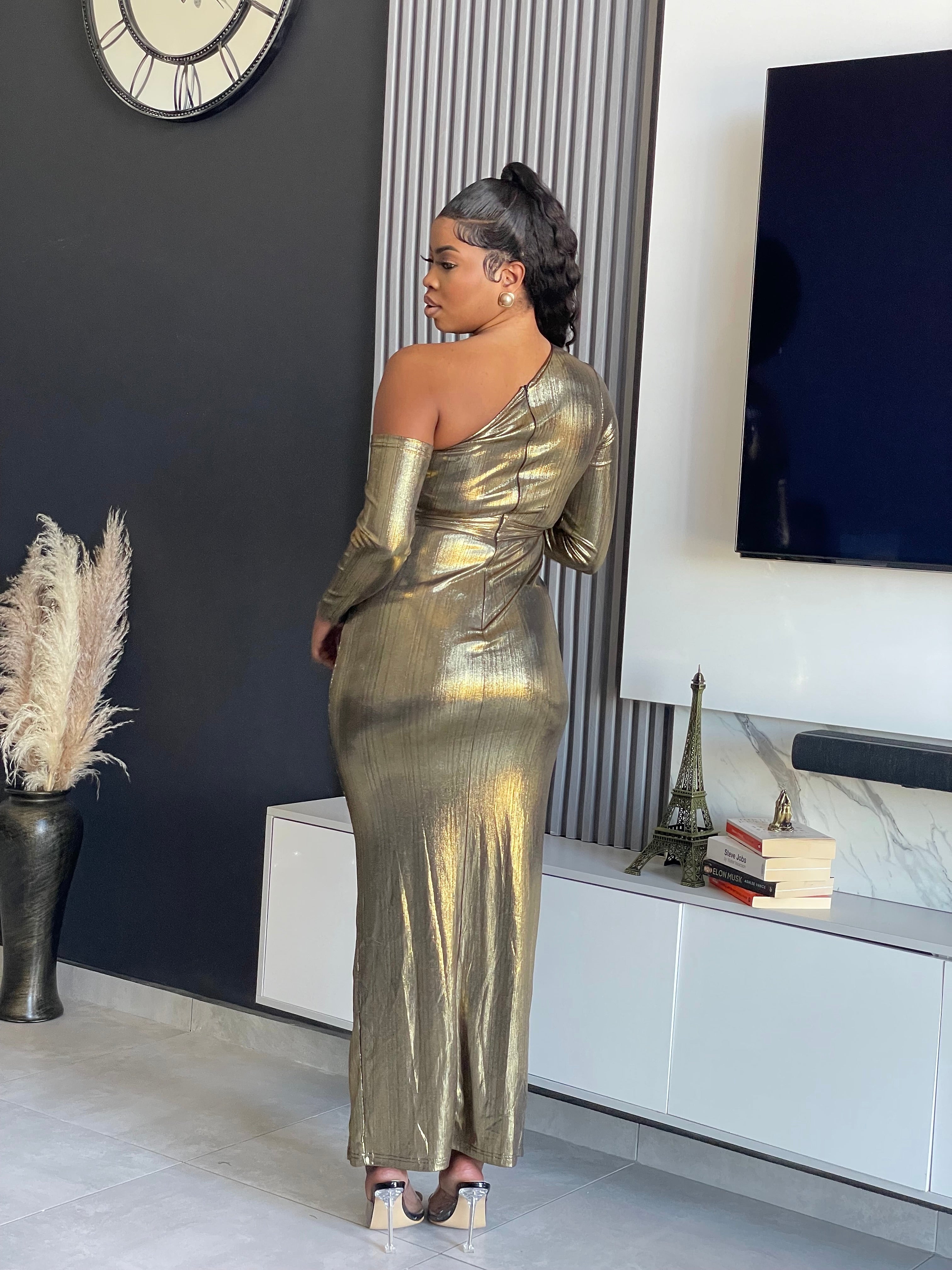 Model wearing the Aiko Metallic Gown, a glamorous one-shoulder metallic gown with a high slit and ruched details from Vera’s Closet.