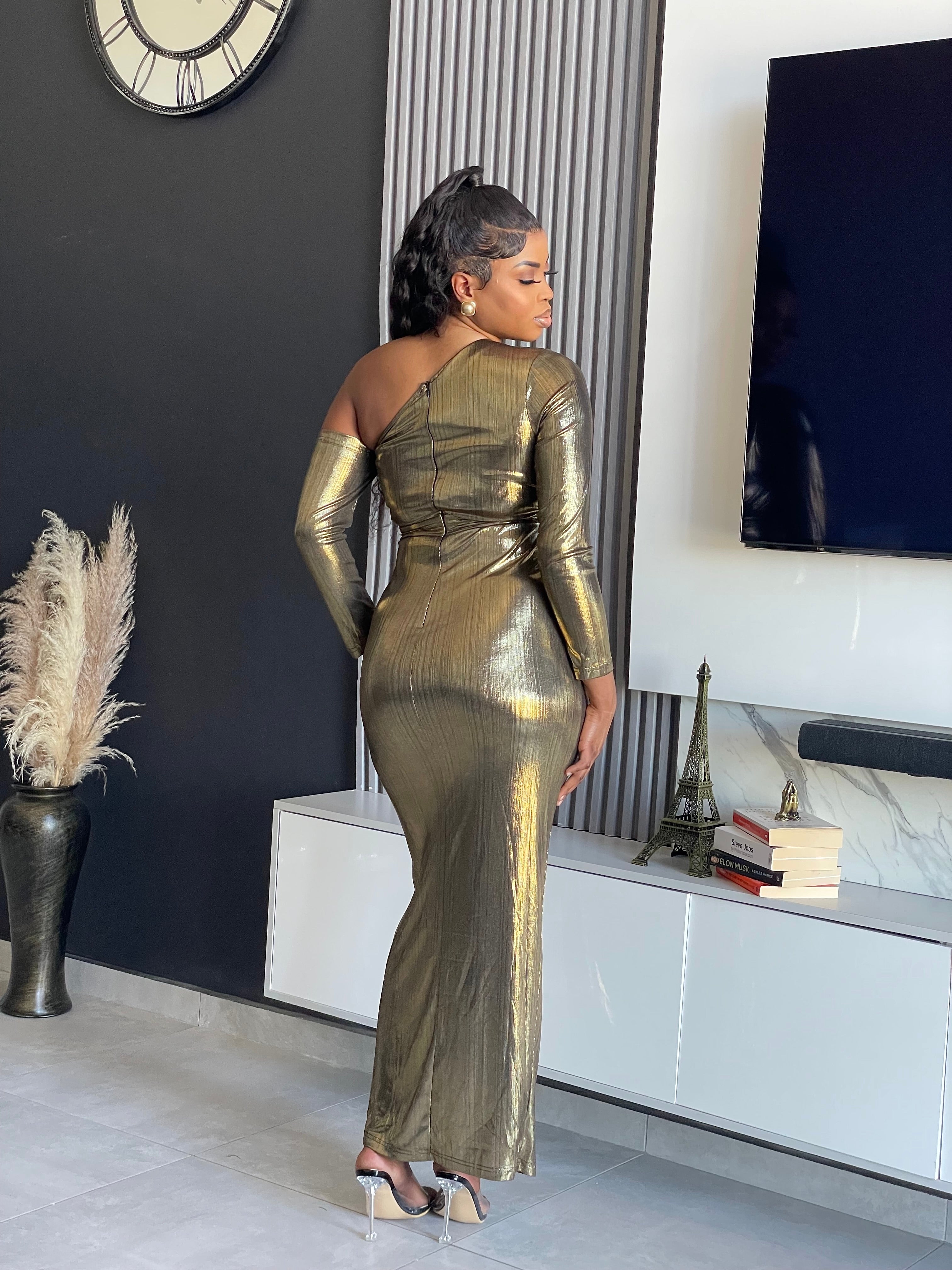 Model wearing the Aiko Metallic Gown, a glamorous one-shoulder metallic gown with a high slit and ruched details from Vera’s Closet.