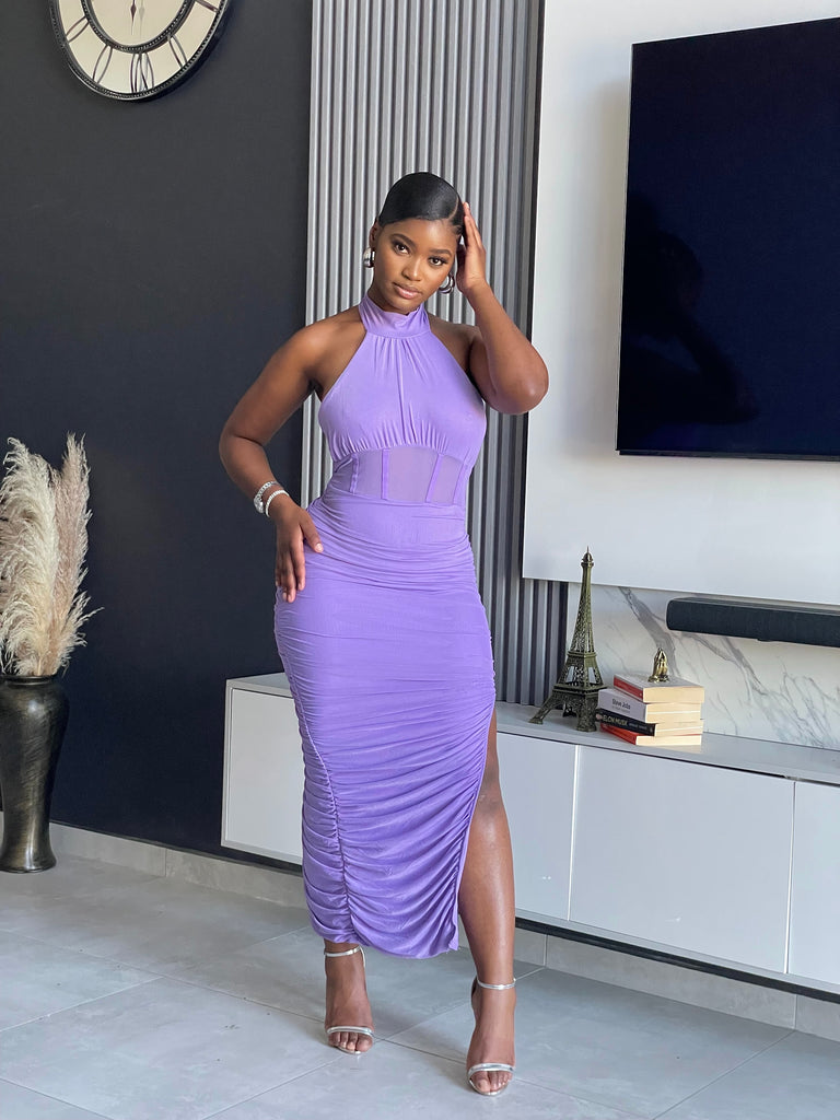 Model wearing the Muse Ruched Midi Dress in a high-neck halter style with ruched detailing and a side slit, from Vera’s Closet.