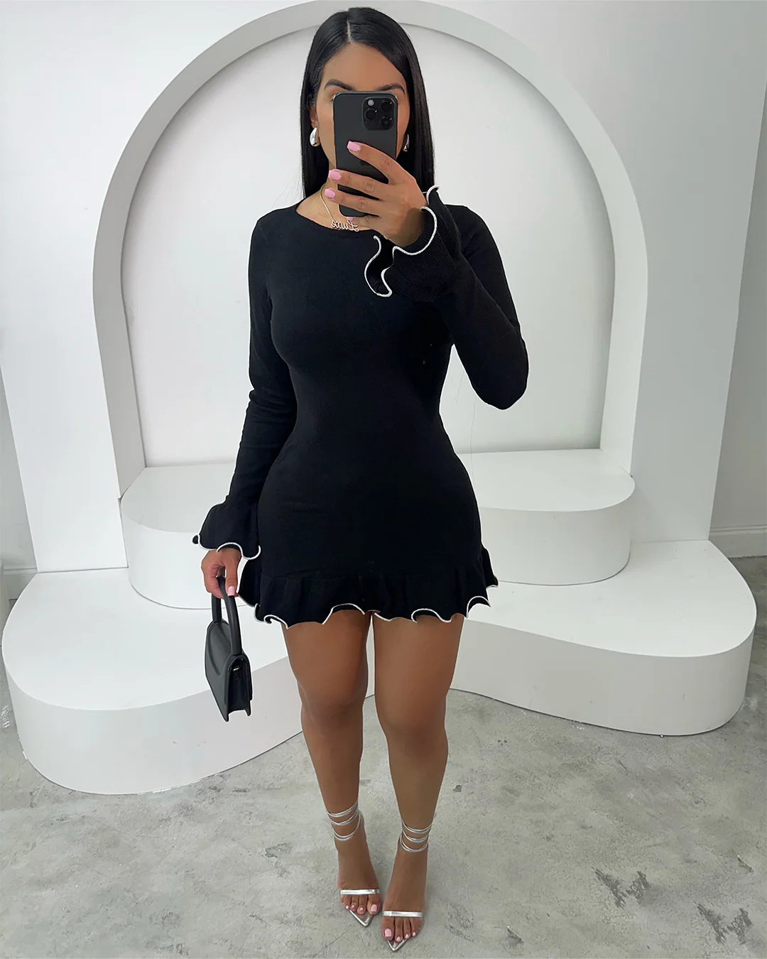 Model wearing Eva Mini Dress in black with stylish white piping, perfect for stylish occasions