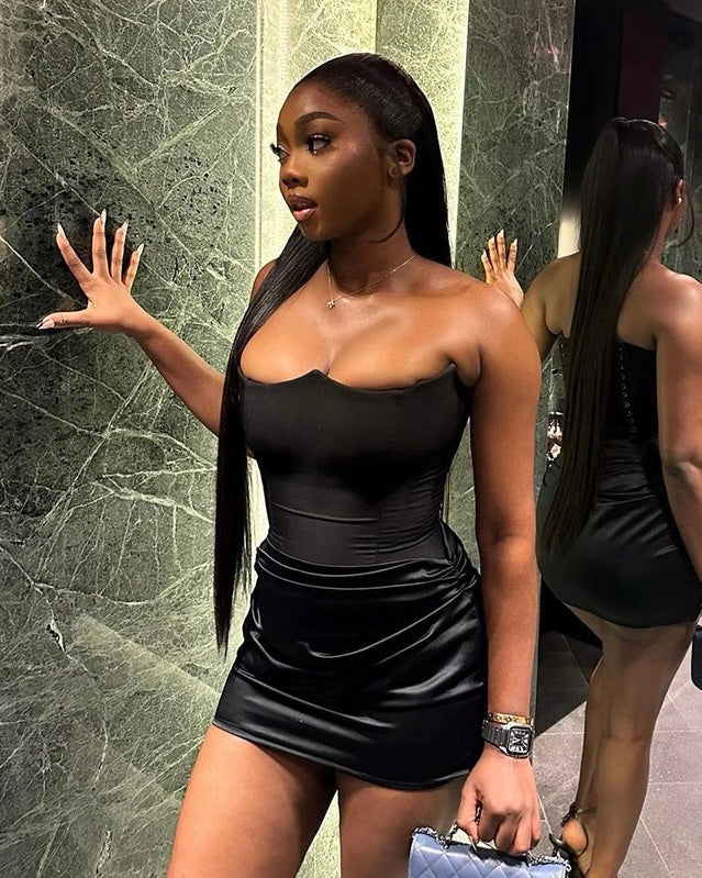 Woman wearing the Black Elegance Strapless Mini Dress with a structured bodice and ruched mini skirt for a sleek and chic look.