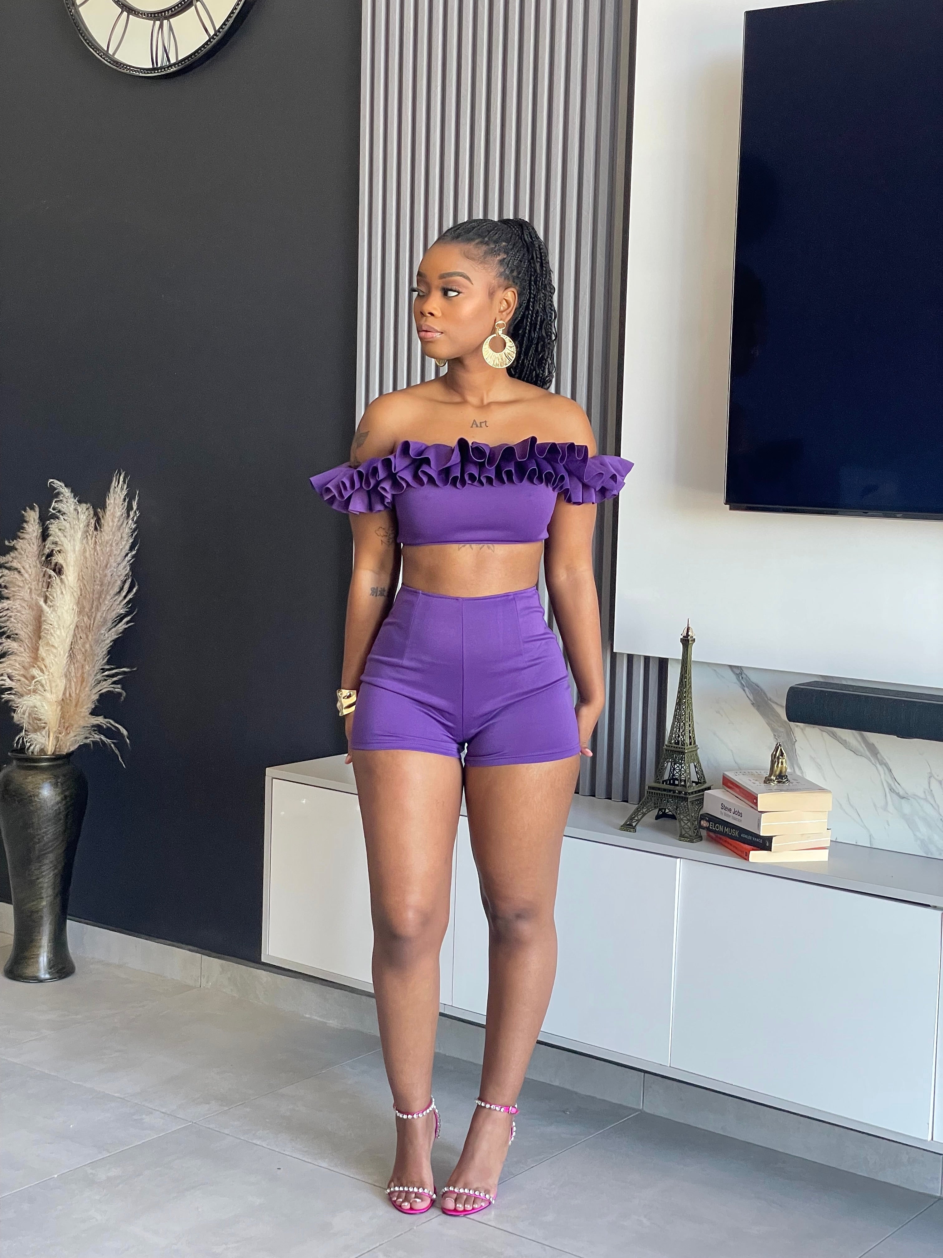 May Ruffle Short Set with off-shoulder ruffle crop top and high-waisted purple shorts.