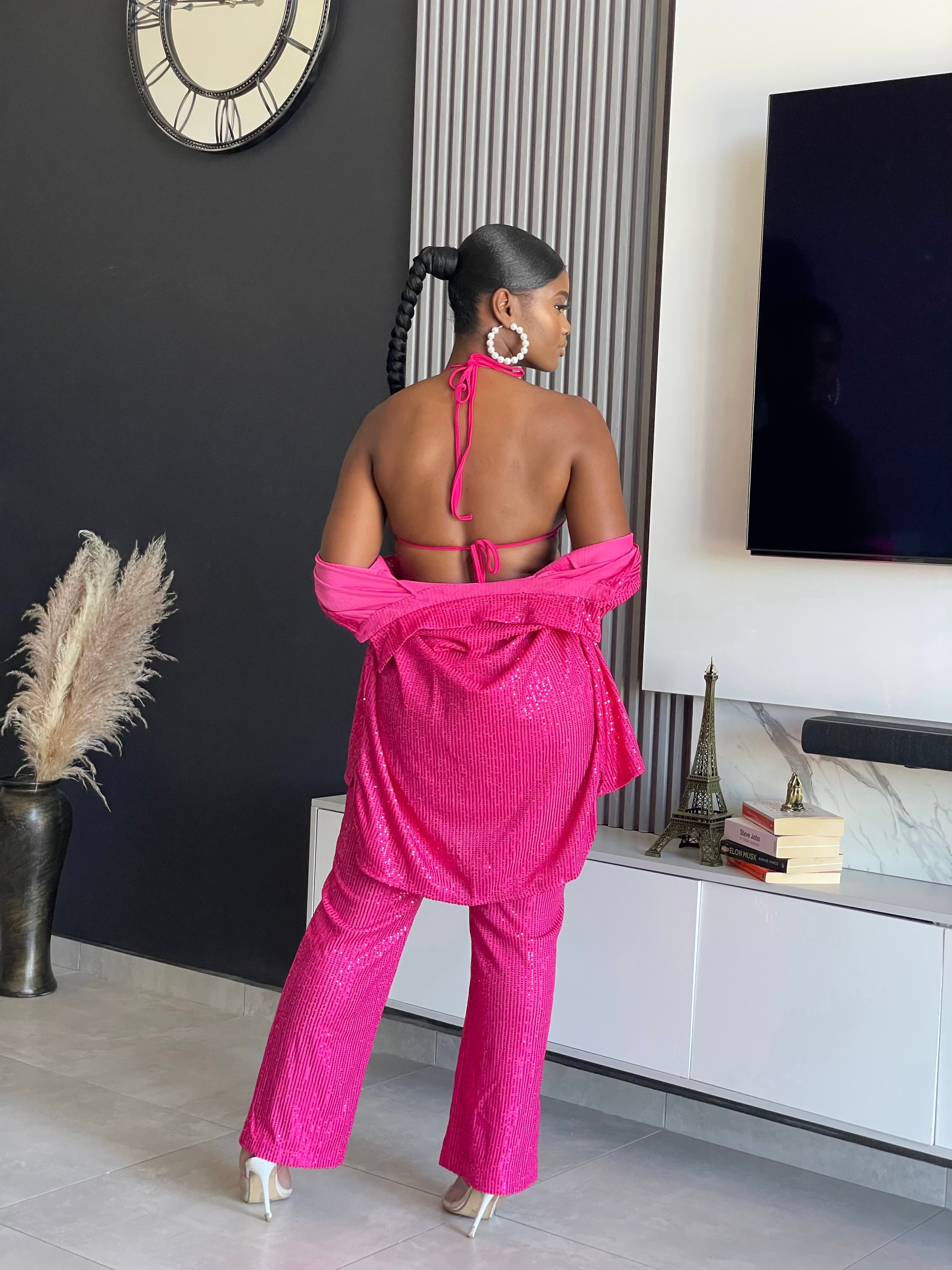 A woman wearing the My First Choice Sequin Pant Set in vibrant pink, featuring a sequin blazer and pants, ideal for making a glamorous fashion statement at any party.