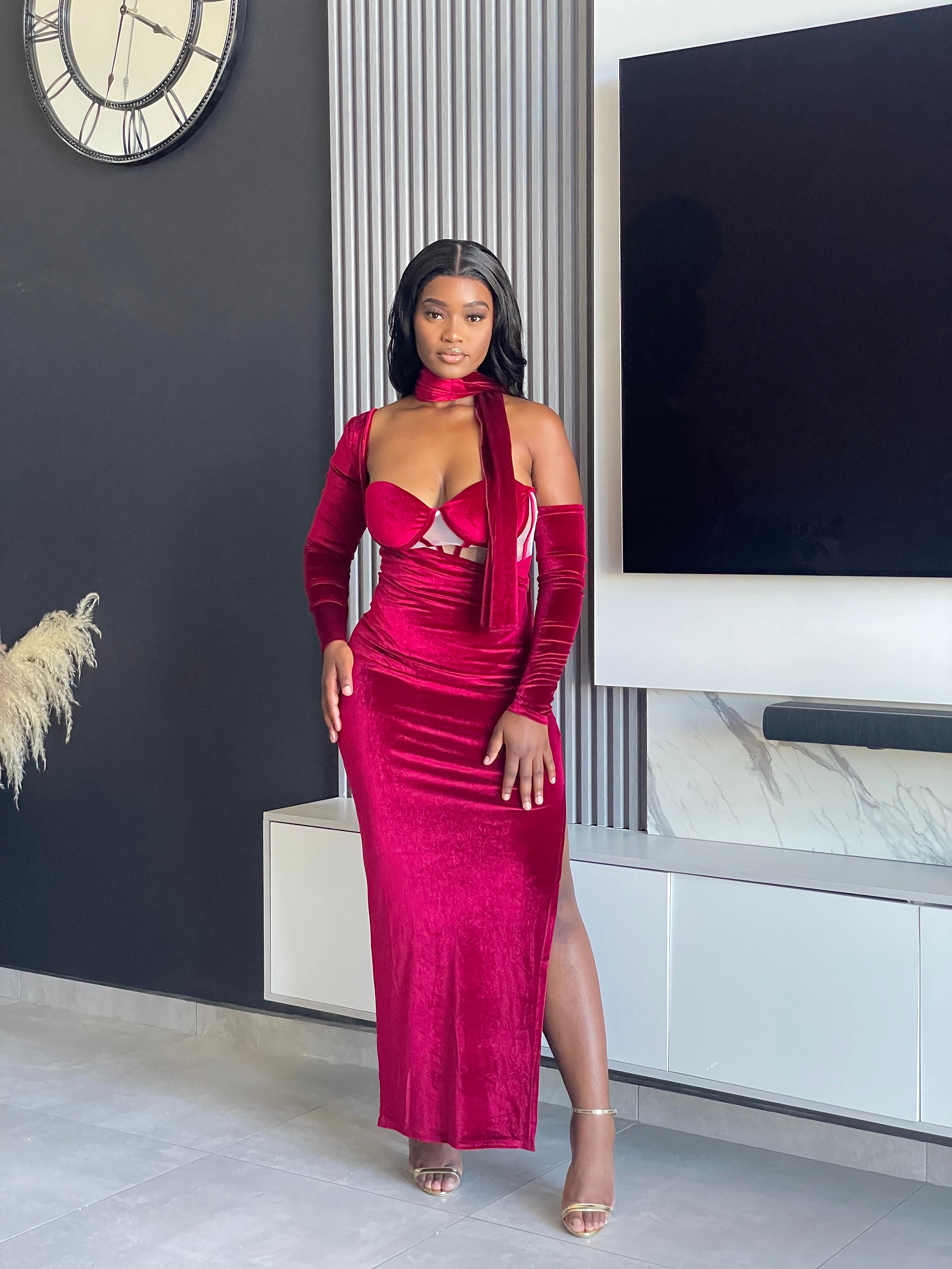 Model wearing the Always Flawless Maxi Dress in red velvet, featuring elegant cutouts and long sleeves, ideal for formal occasions.