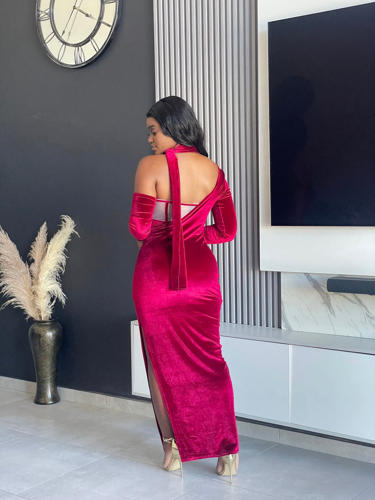 Model wearing the Always Flawless Maxi Dress in red velvet, featuring elegant cutouts and long sleeves, ideal for formal occasions.