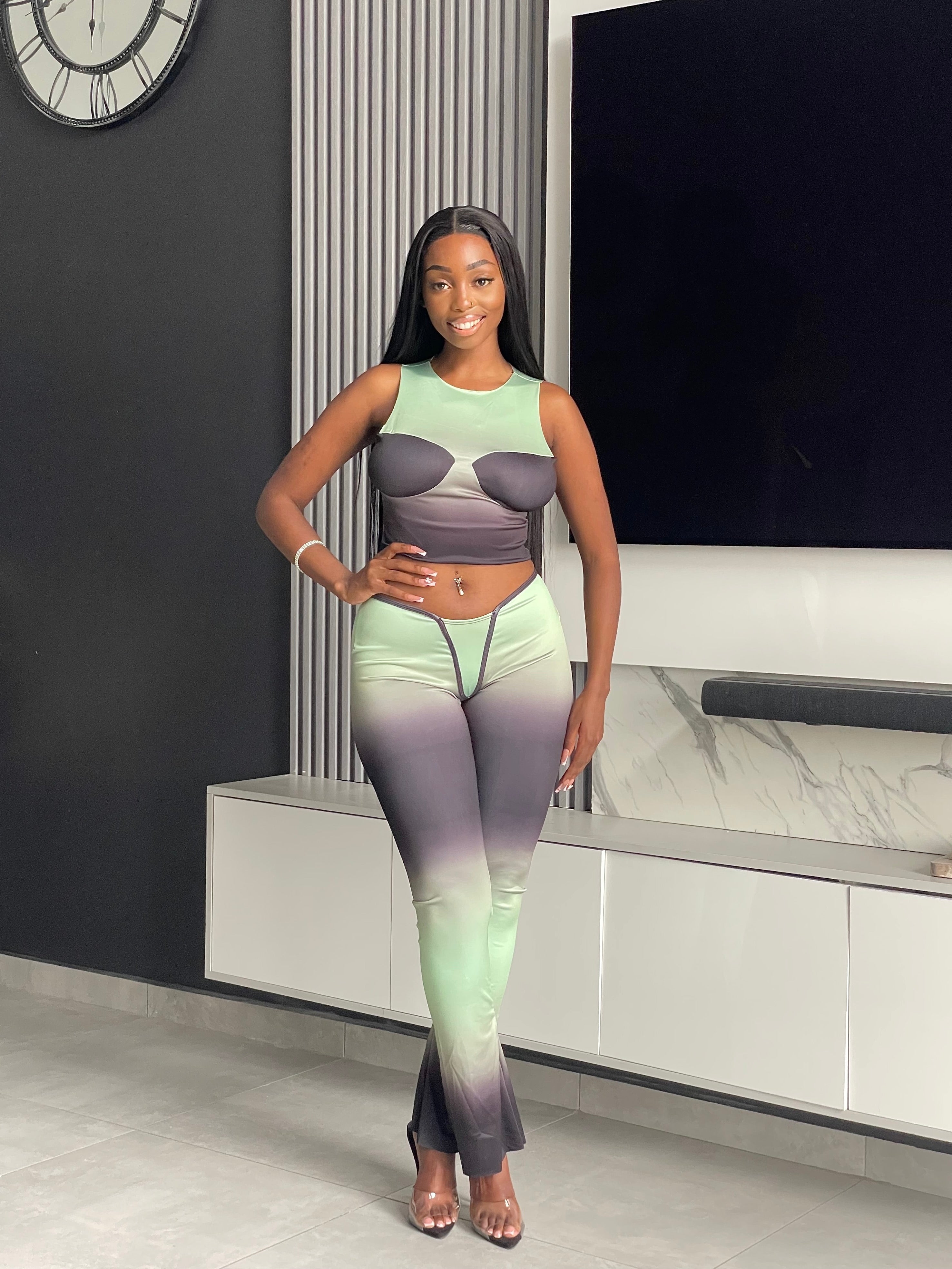 Model wearing the Pasty Pant Set, a chic ombre two-piece outfit with a fitted crop top and flared pants in green and black.