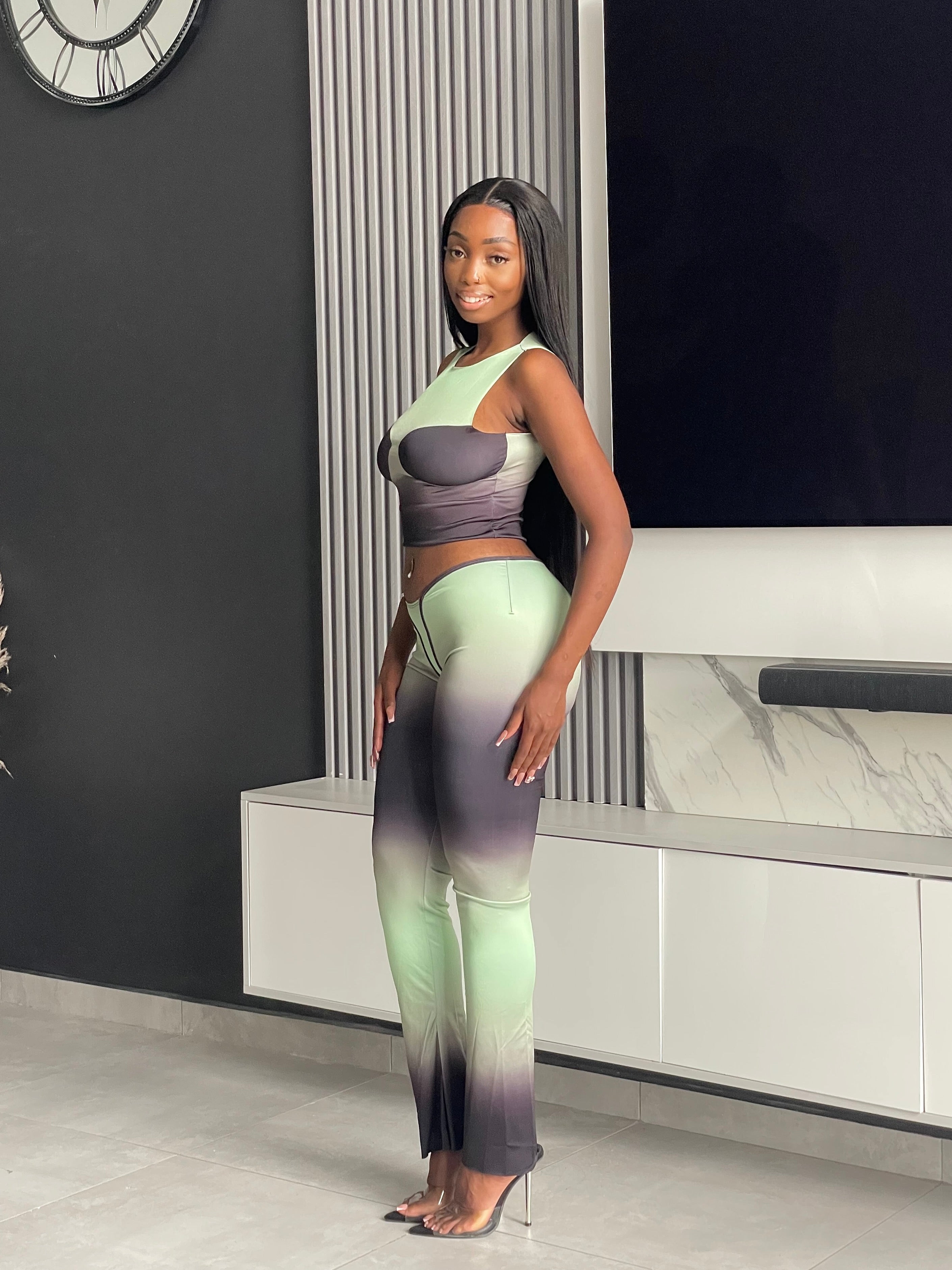 Model wearing the Pasty Pant Set, a chic ombre two-piece outfit with a fitted crop top and flared pants in green and black.