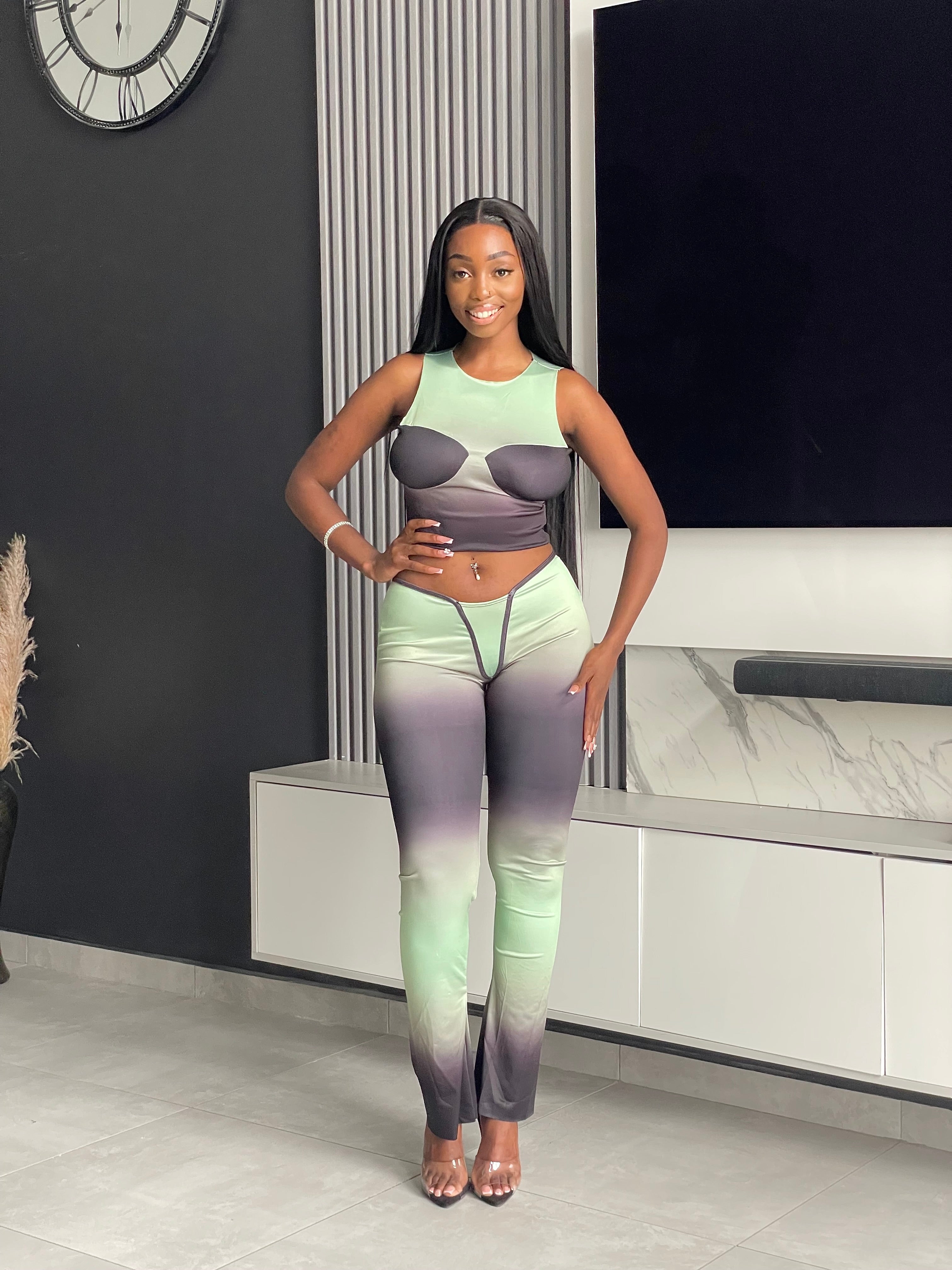 Model wearing the Pasty Pant Set, a chic ombre two-piece outfit with a fitted crop top and flared pants in green and black.