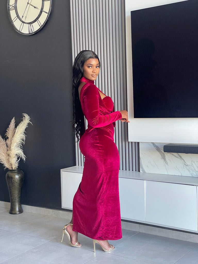 Model wearing the Always Flawless Maxi Dress in red velvet, featuring elegant cutouts and long sleeves, ideal for formal occasions.