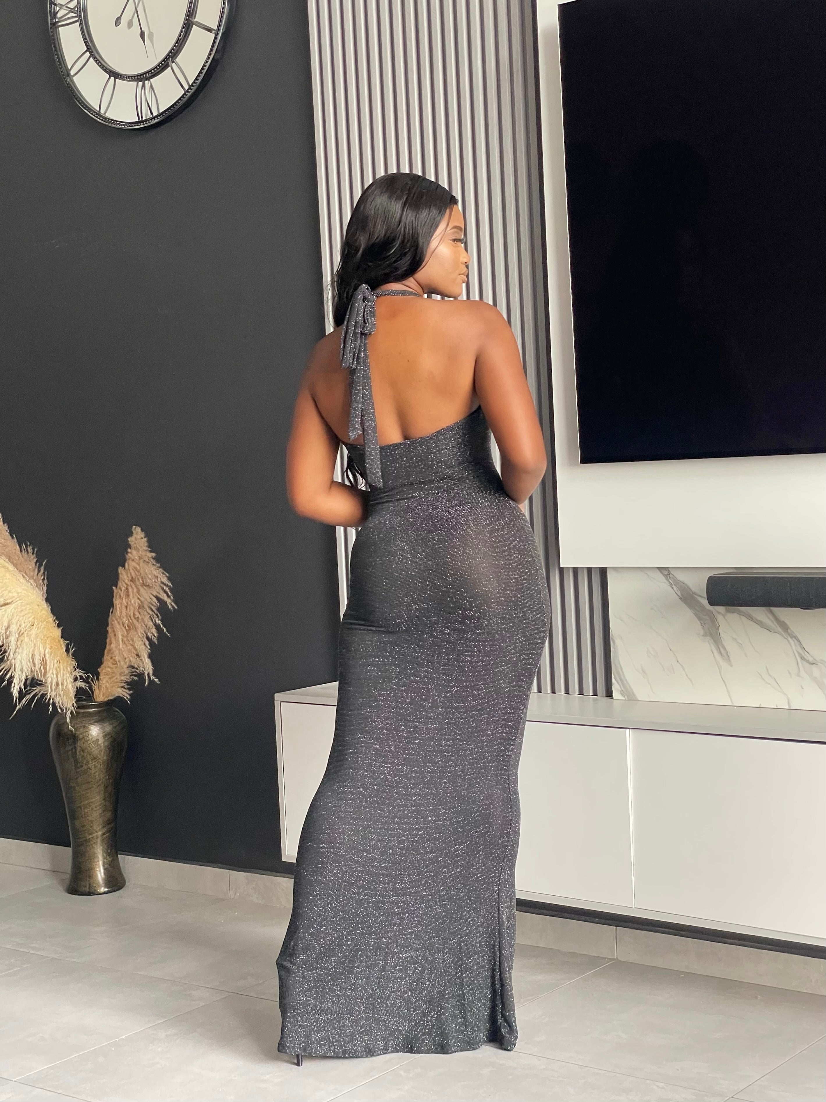 Model wearing Winners Circle Maxi Dress in charcoal grey, featuring a glittery finish and elegant cutout, ideal for formal occasions.