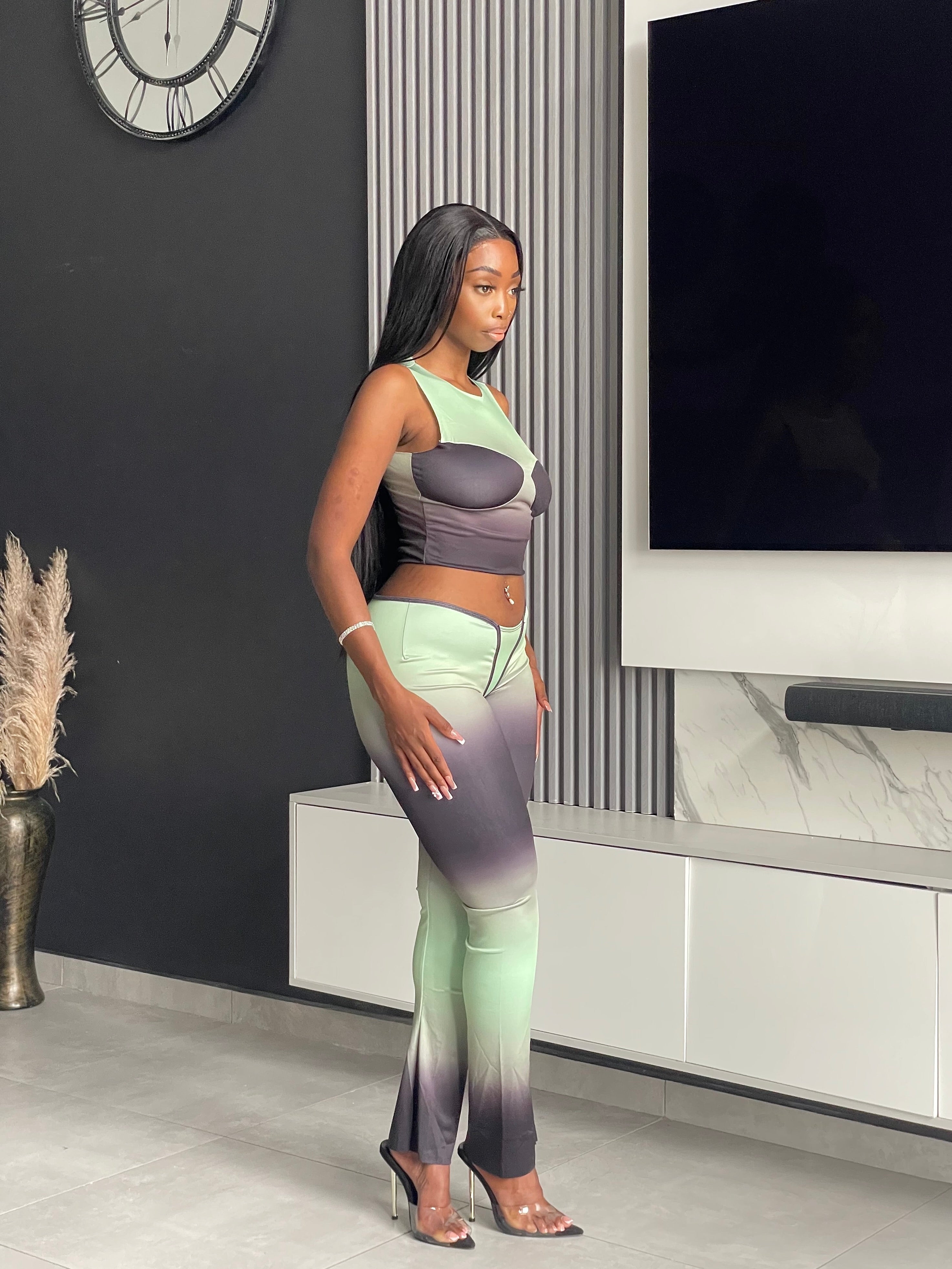 Model wearing the Pasty Pant Set, a chic ombre two-piece outfit with a fitted crop top and flared pants in green and black.