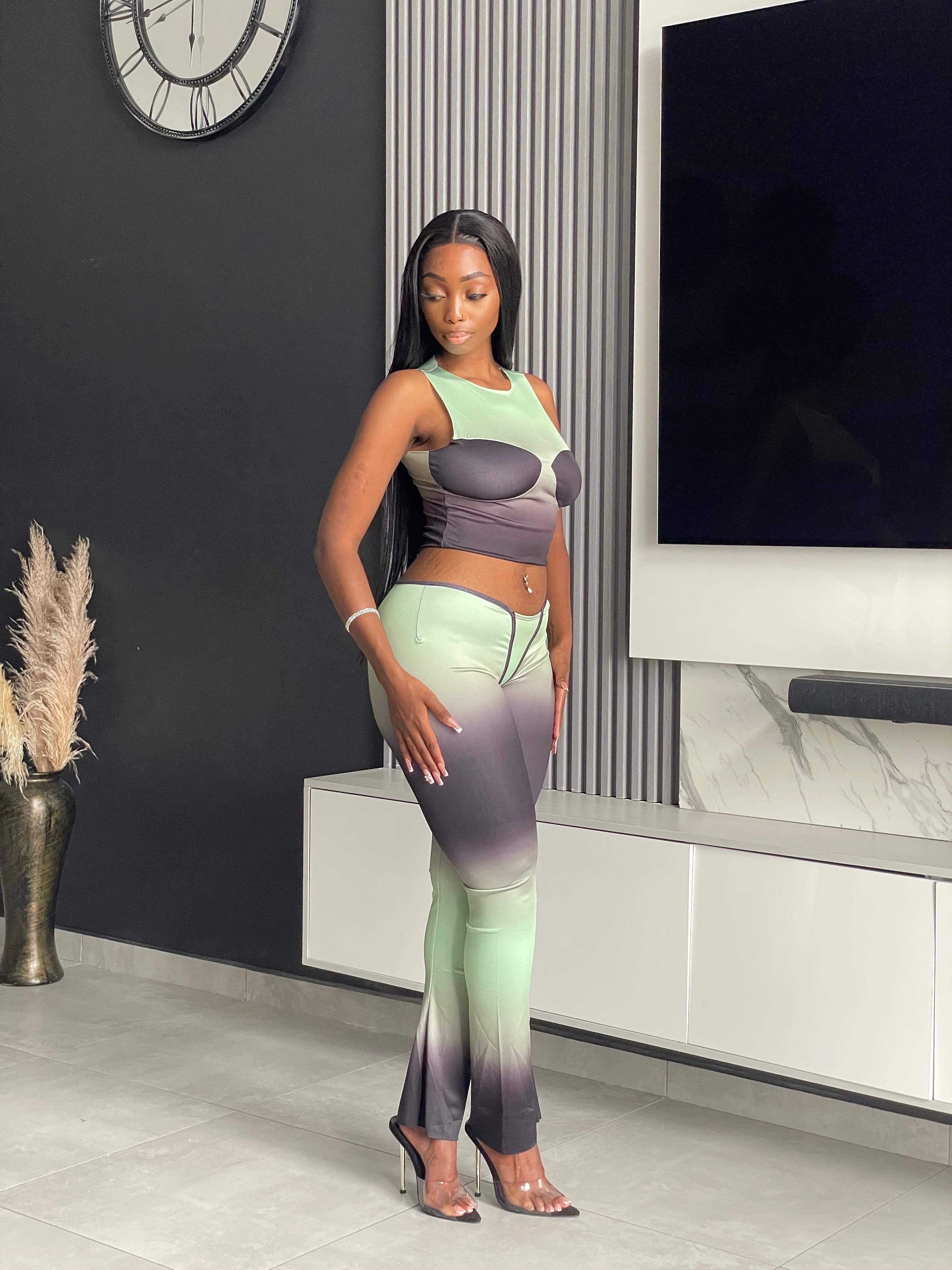 Model wearing the Pasty Pant Set, a chic ombre two-piece outfit with a fitted crop top and flared pants in green and black.