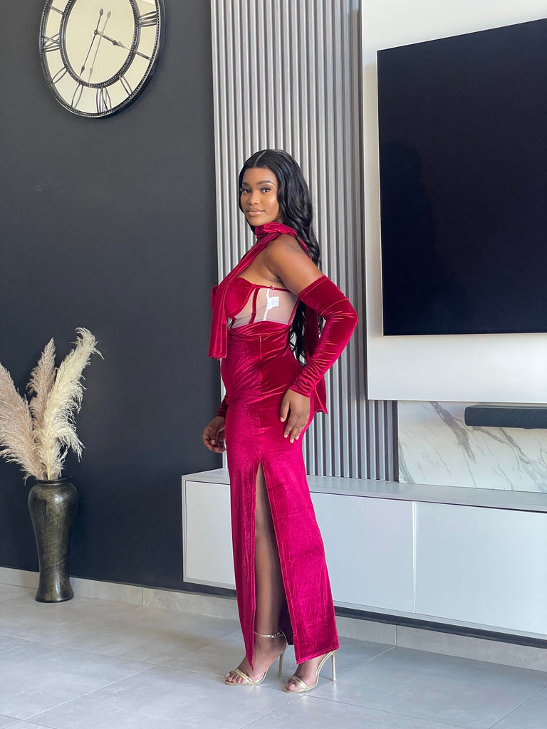 Model wearing the Always Flawless Maxi Dress in red velvet, featuring elegant cutouts and long sleeves, ideal for formal occasions.