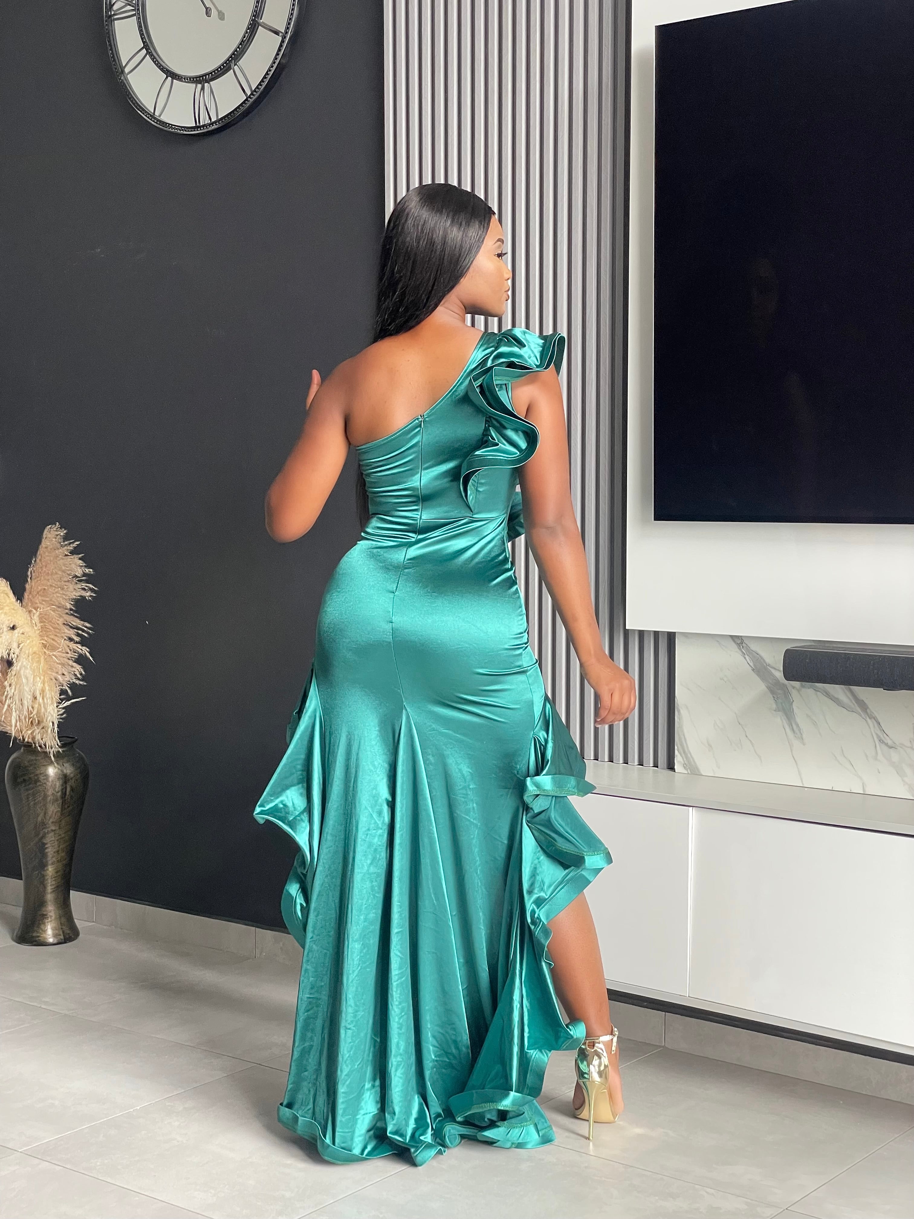 Model wearing She’s Everything Maxi Dress in green, showcasing asymmetrical ruffles and a flowing hem, ideal for formal events.