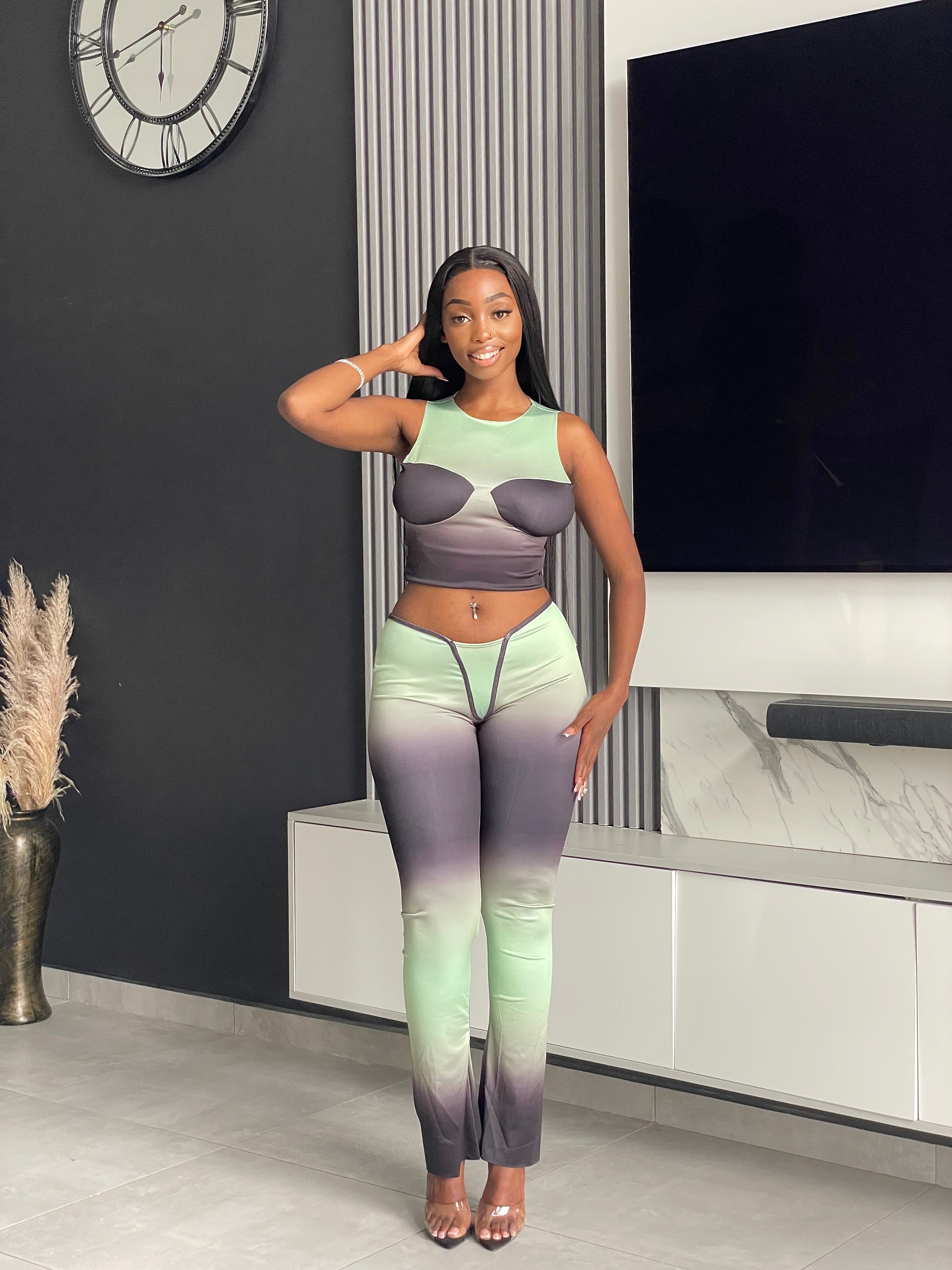 Model wearing the Pasty Pant Set, a chic ombre two-piece outfit with a fitted crop top and flared pants in green and black.