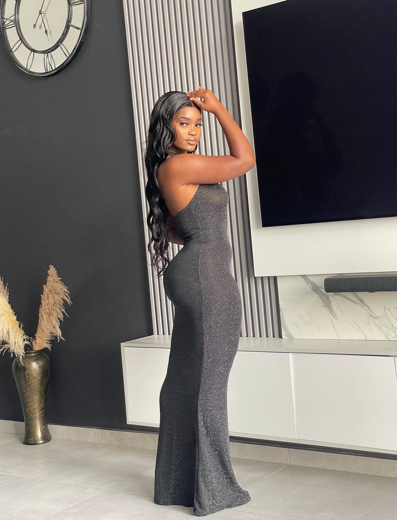 Model wearing Winners Circle Maxi Dress in charcoal grey, featuring a glittery finish and elegant cutout, ideal for formal occasions.