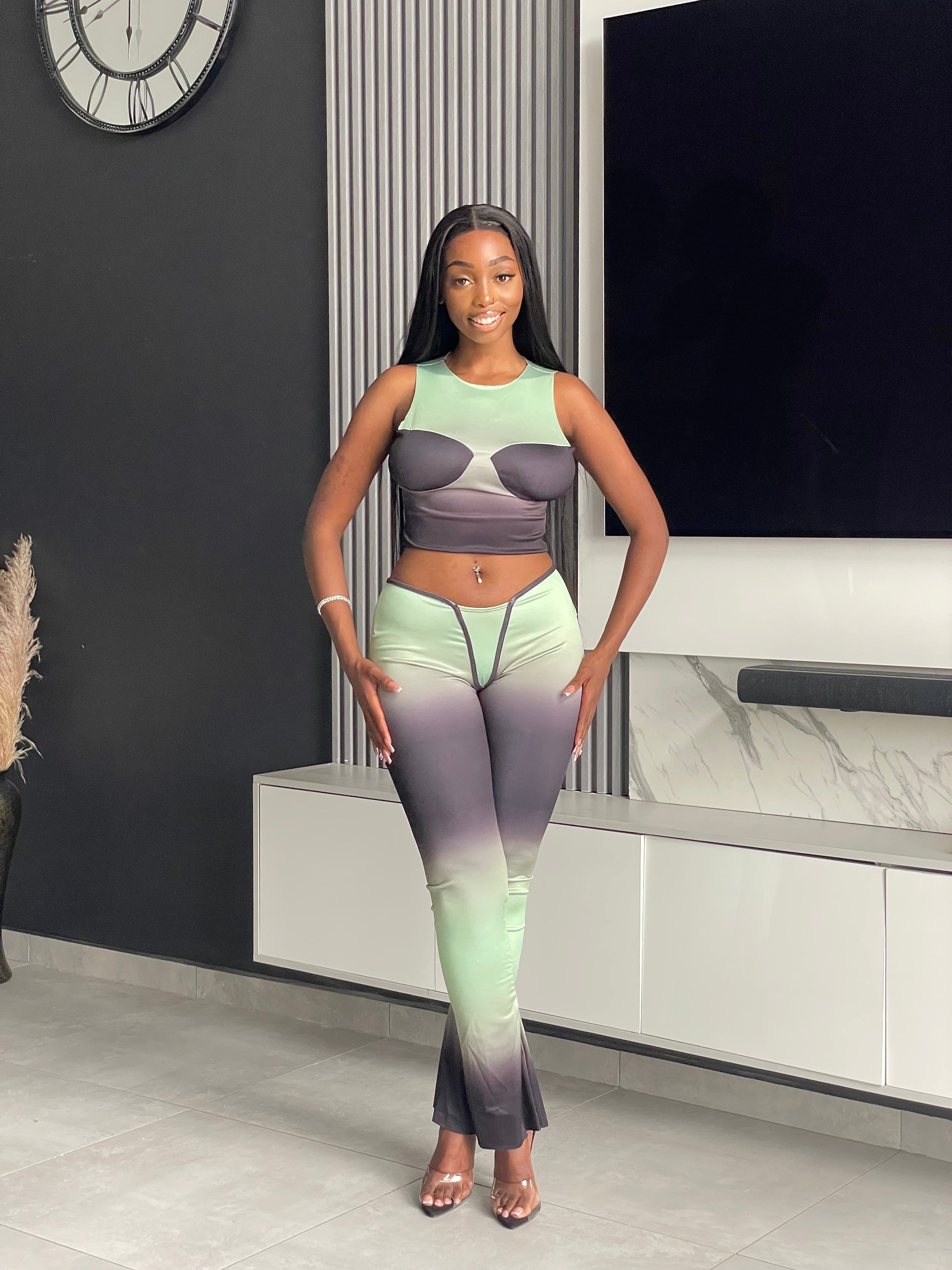 Model wearing the Pasty Pant Set, a chic ombre two-piece outfit with a fitted crop top and flared pants in green and black.