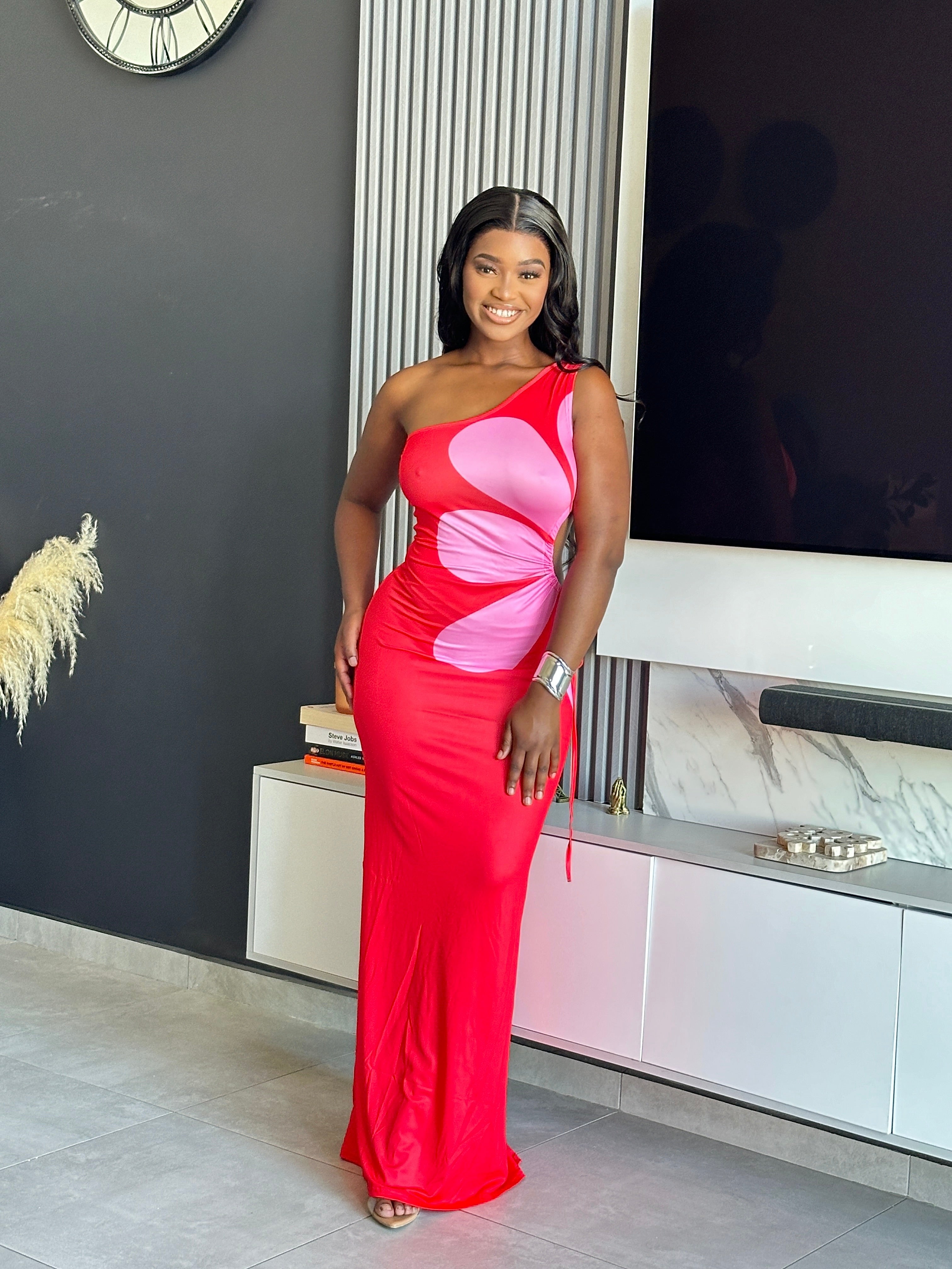 Model wearing the Annabelle Maxi Dress in red and pink with a one-shoulder design.
