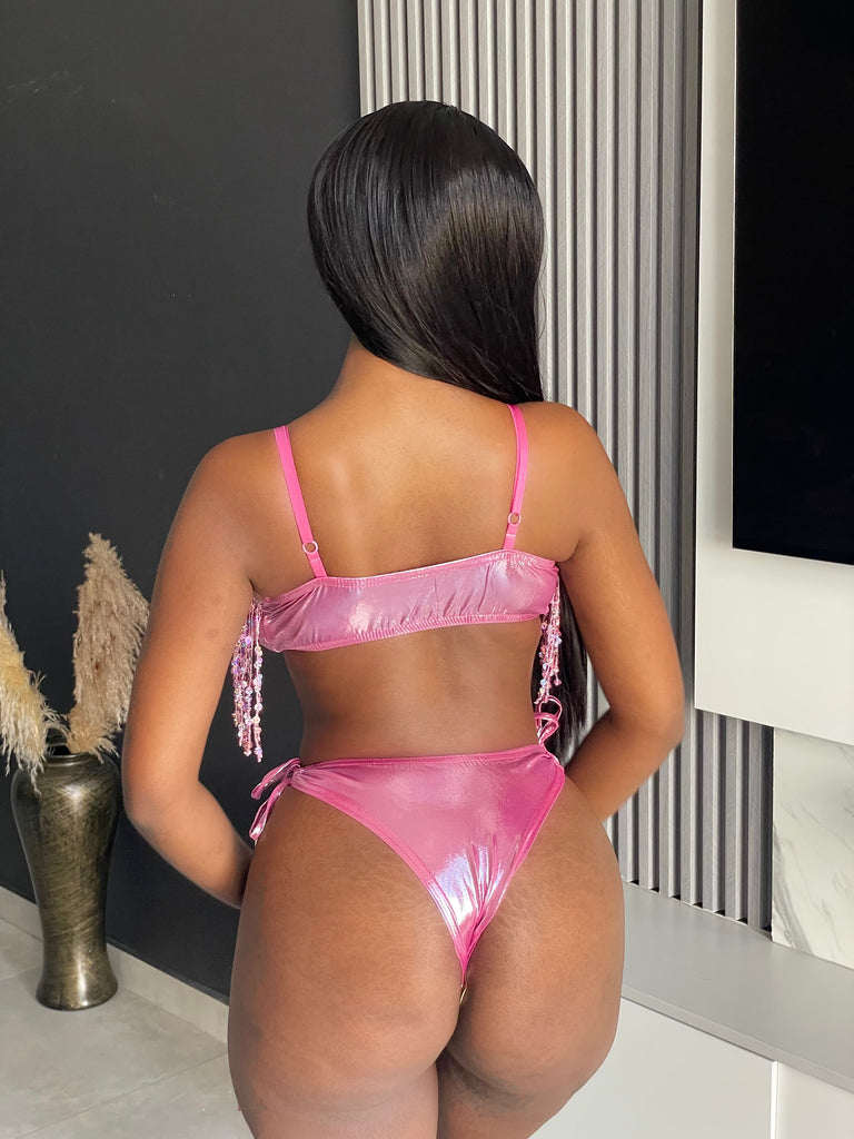 Model wearing the Auja Bikini, a pink sequin two-piece set featuring a fringe crop top and adjustable side-tie bottoms, perfect for beach days or poolside glamour.