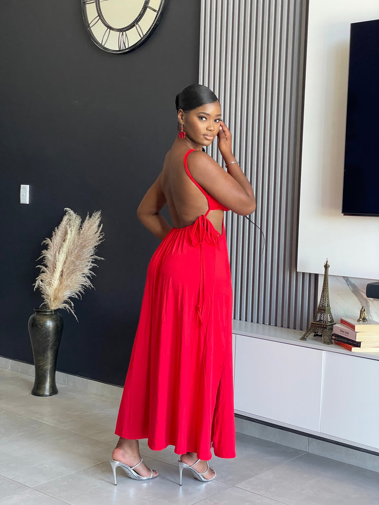 A woman wearing the Hiamovi Maxi Dress in radiant red, featuring deep V-neckline and elegant cut-outs, perfect for elegant gatherings