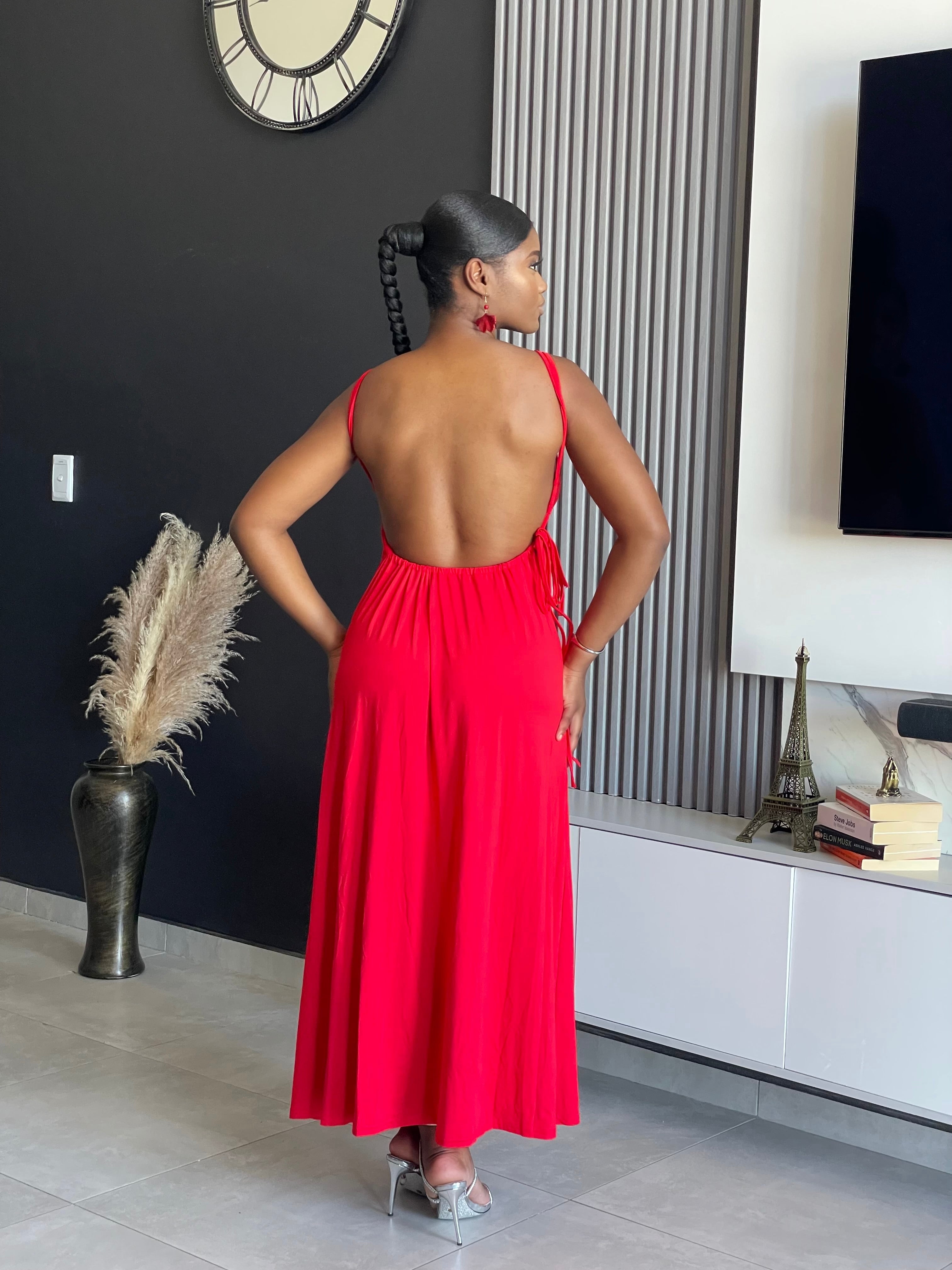 A woman wearing the Hiamovi Maxi Dress in radiant red, featuring deep V-neckline and elegant cut-outs, perfect for elegant gatherings