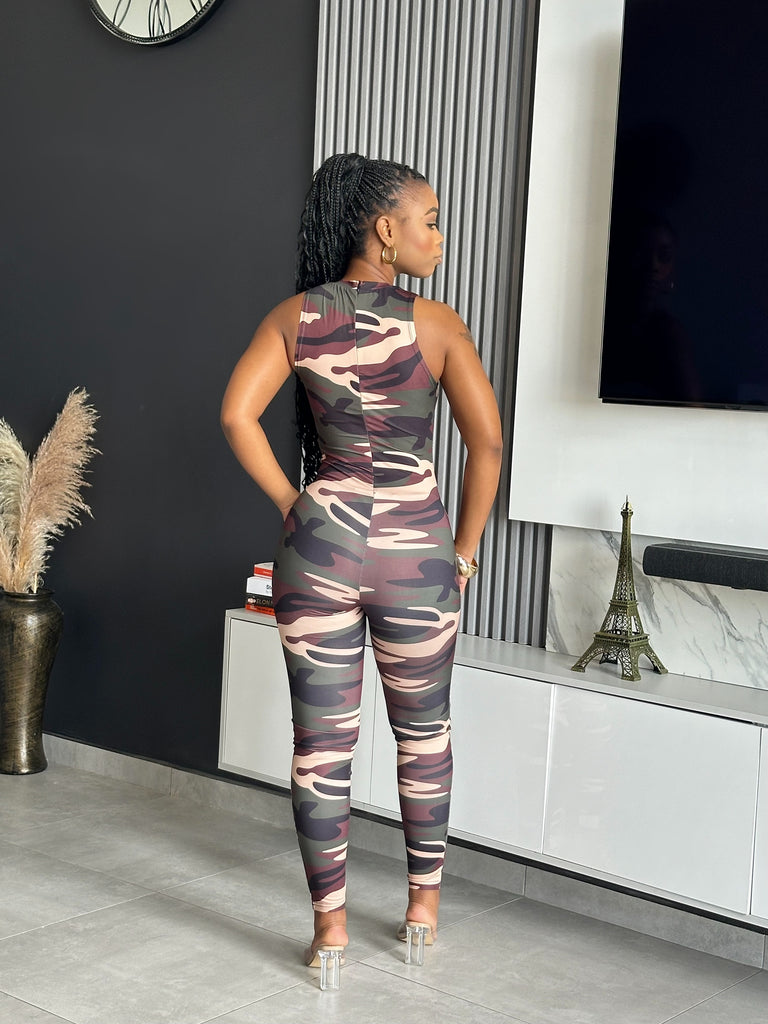 Model wearing the Nedia Jumpsuit, a camo print one-piece with a sleeveless design and form-fitting silhouette